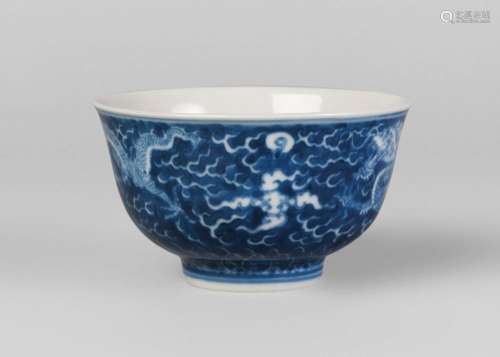 A Chinese porcelain bowl, Yongzheng mark, 20th century, painted in underglaze blue with two dragons chasing the flaming pearl amidst cloud wisps, the inside medallion painted with a dragon medallion, underglaze blue seal mark to base, 6cm high, 10cm diameter