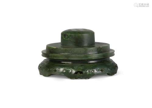 A Chinese spinach jade joss stick holder, Qianlong period, of circular form, the foot carved and pierced with archaistic motifs, 6.5cm diameter