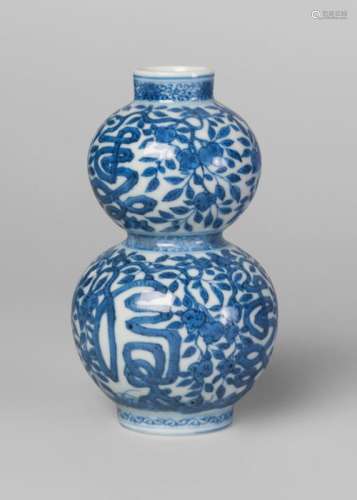 A Chinese porcelain Ming style double gourd vase, Wanli mark, Republic period, painted in underglaze blue with fruiting peach branches amidst six shou characters, underglaze blue six-character mark within a double ring to base, 13cm high