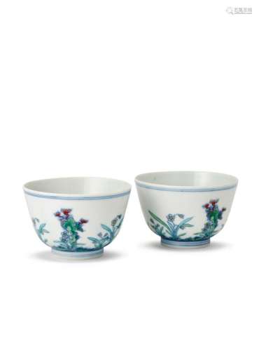 A pair of Chinese porcelain doucai tea bowls, Kangxi mark, painted to the exterior in underglaze blue and overglaze enamels with a continuous scene of flowering foliage and three lingzhi sprigs issuing from a rocky outcrop, 5.5cm high
