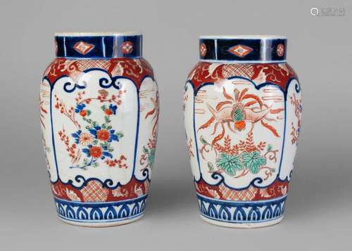 A pair of Japanese imari vases, late 19th century, each painted with panels of floral sprays and birds, 22cm high