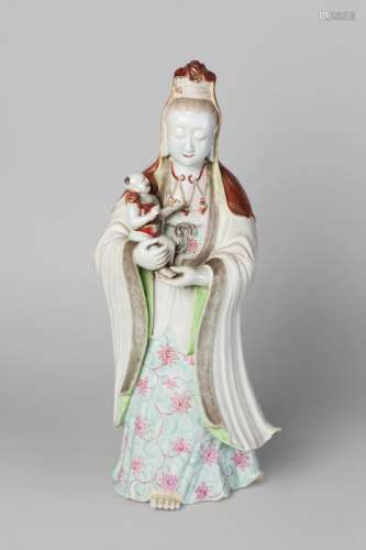A large Chinese porcelain famille rose figure group of Guanyin and child, late 18th/early 19th century, wearing beaded necklace and hooded shawl decorated in gilt on a coral ground, her robe sgraffito decorated, 51cm high