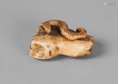 A Japanese ivory netsuke, mid-19th century, finely carved as a snake on a log, signed, 3.8cm long