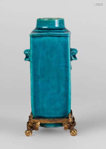 A Chinese monochrome porcelain square vase, Kangxi period, with allover turquoise glaze and moulded with Buddhist lion mask and ring handles, the base with gilt metal mounts, 15cm high