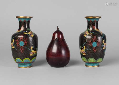 A pair of Chinese cloisonne vases, 20th century, each decorated with confronting dragons on a black ground, 16.5cm high, and a 20th century carved wood pear-shaped tea caddy (3)