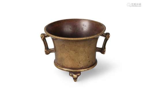 A Chinese gilt bronze censer, Xuande mark but 18th/19th century, of cylindrical flared form, with archaistic handles, and raised on three elephant mask feet, 9cm high, 13cm wide, 485 grams