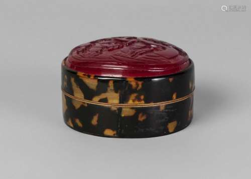 A Chinese Peking glass and tortoiseshell cosmetics box, late Qing dynasty, the red glass-inset cover carved in relief with Shoulao and a boy beneath a pine tree, 7cm diameter