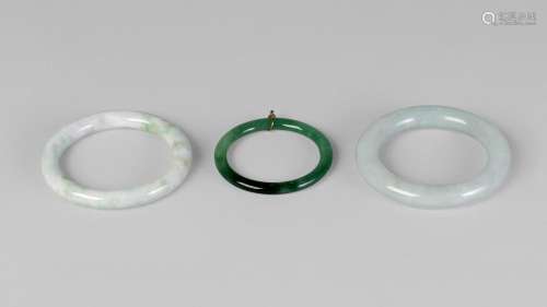 Two Chinese pale green hardstone bangles, 20th century, 8cm diameter, and a child's bangle (3)