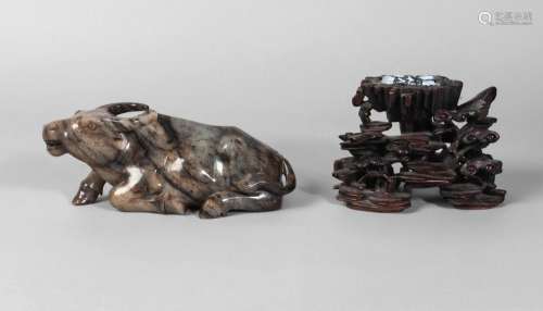 A Chinese mottled jade carving of a buffalo, early 20th century, carved in recumbant pose, 17cm long, and a 19th century hardwood stand carved with lingzhi, 8.5cm high (2)