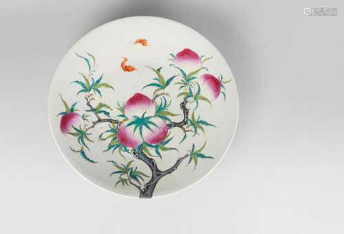 A large Chinese porcelain famille rose 'bats and peaches' charger, mid 19th century, finely painted with a fruiting peach tree issuing from the footrim, to the underside, and the surface, and with two bats in flight, 48cm diameter