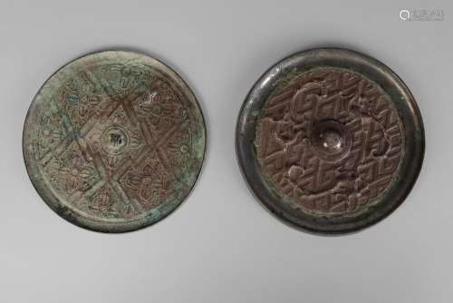 A Chinese bronze Tang style mirror, 20th century, cast with dragons and phoenix on a geometric ground, 16cm diameter, and a similar mirror decorated with floral motifs, 15.5cm diameter