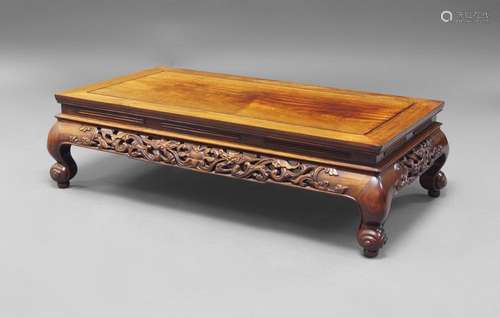 A Chinese hardwood low table, kang, 20th century, the rectangular top above carved and pierced frieze decorated with confronting dragons, 30cm x 108cm x 61cm