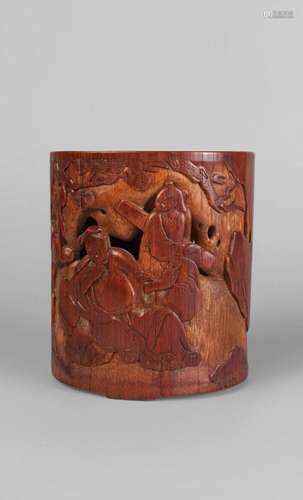 A Chinese bamboo brush pot, 18th/19th century, pierced and carved in low relief with a scholar and a companion seated beneath a pine tree, and a figure approaching, 15cm high