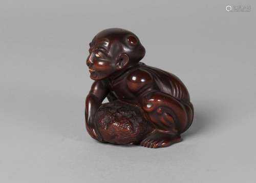 A Japanese boxwood netsuke of a Totsuka beggar, mid-19th century, the so-called 'blind stone-lifter' wearing a fundoshi and lifting a boulder, signed Gyokkei to ivory tablet, 6.5cm high