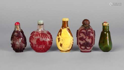 Four Chinese cameo glass snuff bottles, late 19th/early 20th century, three red over clear glass, carved with dragons and oxen, the fourth yellow over amber, carved with carp, 8cm-6.5cm, and a gold specked green glass example (5)