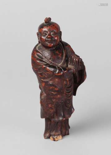 A Chinese rootwood carved figure, 17th century, finely carved as a young boy praying, with smiling expression, 15cm high