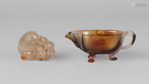 A Chinese agate jug, early 20th century, 8cm long, and a carved agate 'longevity' pendant, carved with a monkey, peach, and a bat, 4.5cm high (2)