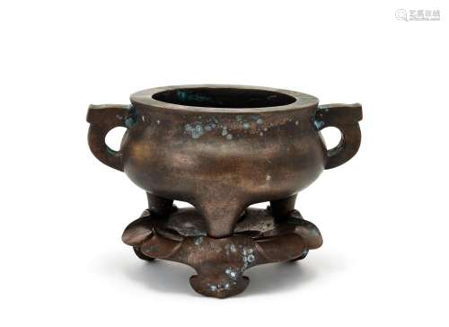 A large Chinese bronze 'qian qing gong' tripod censer and stand, Zhengde mark, 17th/18th century, cast with archaistic handles on three short feet each inscribed 'qian', 'qing', and 'gong', on lotus cast stand, 22cm wide, 14.5cm high (including stand), 4273 grams Cf. For a censer with qian qing gong character marks to feet, see Sotheby's, Hong Kong, 1st June 2015, Lot 792