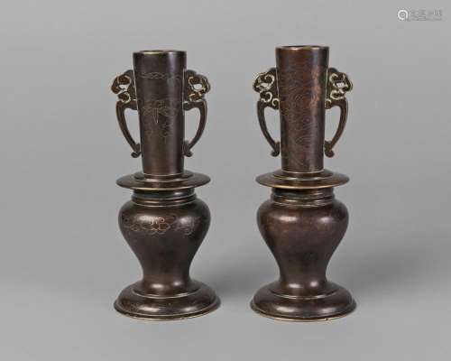A pair of Chinese bronze and silver inlaid altar vases, Qianlong period, with archaistic handles to elongated, slightly tapering neck, inlaid with clouds to one, and bamboo to the other, above baluster main body and spreading foot, recessed base, 792 grams, 14.5cm high