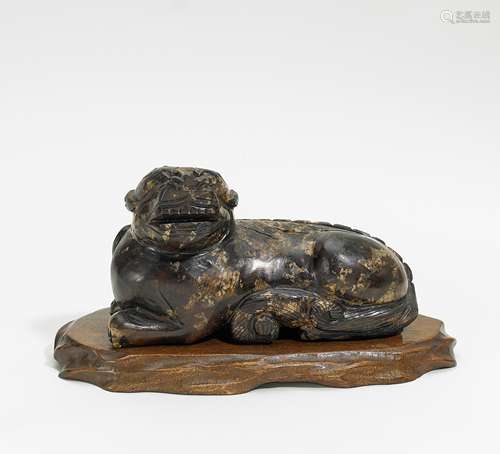 LIEGENDER LÖWENHUND. China. Speckstein. H. 10,5cm, L. 18,5cm. Zustand A/B. Beilage: Holzsockel.