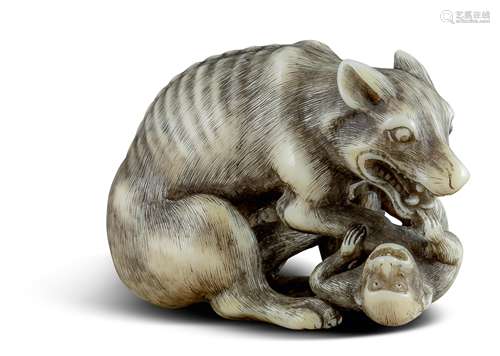 NETSUKE: WOLF MIT AFFE. Japan. Edo-Zeit. 2. H. 18. Jh. Sitzender, magerer Wolf mit