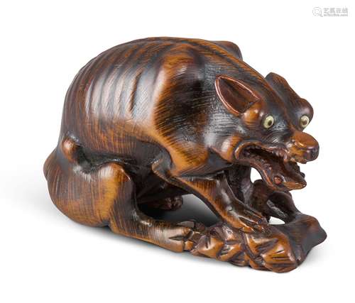 NETSUKE: WOLF MIT HIRSCHKEULE. Japan. Edo-Zeit. Spätes 18. Jh. Buchsbaum mit fein gravierten