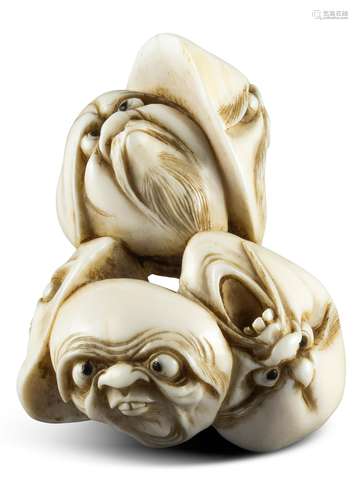 NETSUKE: MASKENGRUPPE. Japan. Edo-Zeit. 19. Jh. Elfenbein mit fein gravierten und dunkel