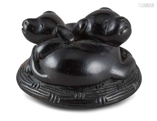 NETSUKE: ZWEI HÜNDCHEN. Japan. Edo-Zeit. 19. Jh. Schwarzes Kakiholz, fein geschnitzt und graviert.