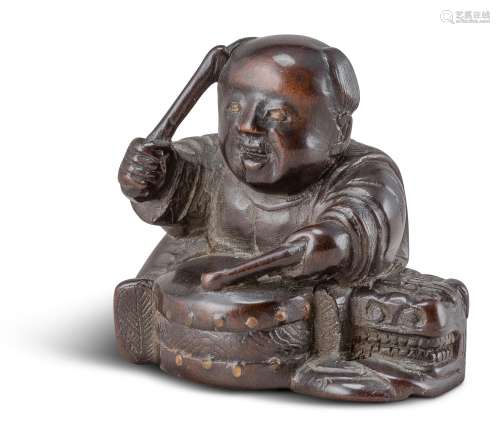 NETSUKE: KARAKO MIT TROMMEL. Japan. Edo-Zeit. Frühes 19. Jh. Dunkelbraunes Holz, fein geschnitzt und
