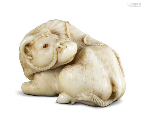 NETSUKE: LIEGENDES RIND. Japan. Edo-Zeit. 19. Jh. Liegendes Rind, den Kopf umgewandt, mit Halfter