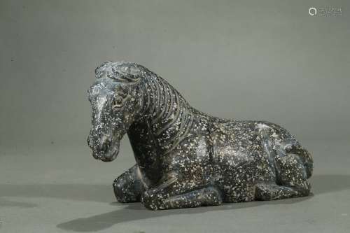 A stone carving of recumbent horse