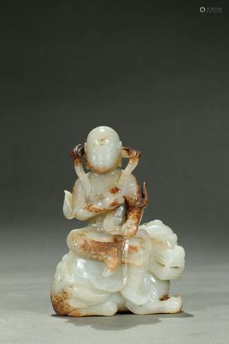 A white jade carving of arhat on lion