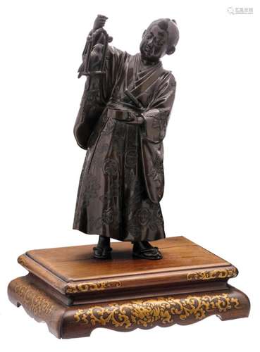 A Japanese bronze figure depicting a noble man holding a parrot, on a matching gilt wood decorated base, marked, H 23,5 (without base) - 29,5 cm (with base)