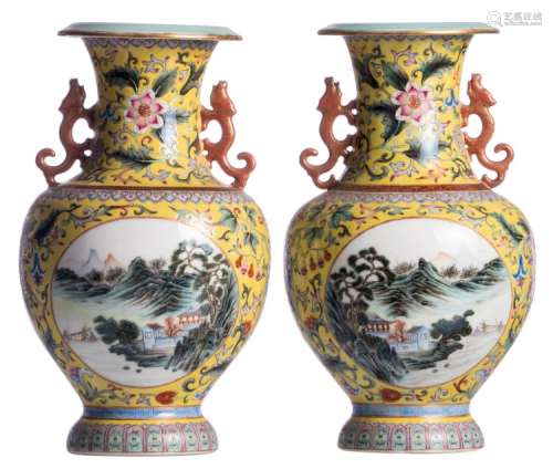 A pair of Chinese yellow ground polychrome and floral decorated vases, the roundels with mountainous river landscapes, the handles dragon relief decorated, with a Qianlong mark, H 31,5 cm