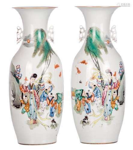 A pair of Chinese polychrome decorated vases with a lady and boys playing in a garden and calligraphic texts, H 58 - 58,5 cm