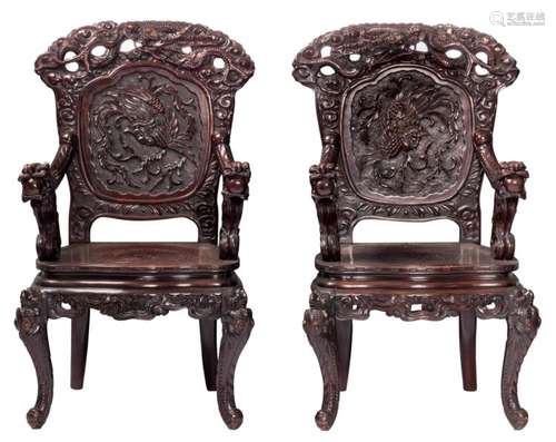 A pair of Japanese richly carved wooden armchairs, decorated with dragons and mythical birds, H 111- W 61 - D 53 cm