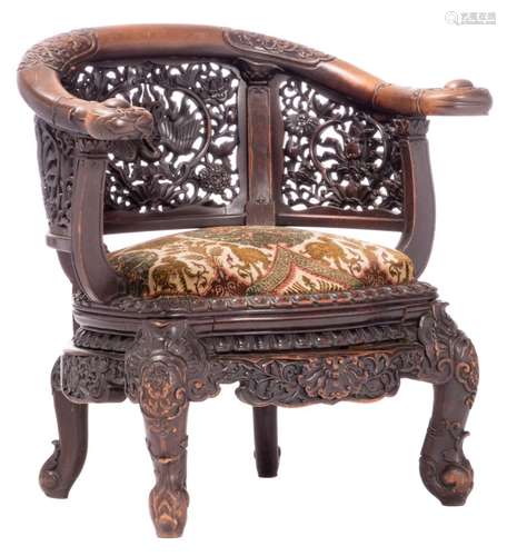 A richly carved and openworked phoenix and lotus flower decorated wooden oxbow armchair, H 81 cm