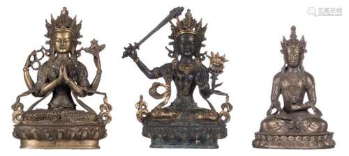 Two Tibetan seated bronze Buddhas on a lotus shaped base; added a ditto Buddha in paktong, H 19 - 22 cm