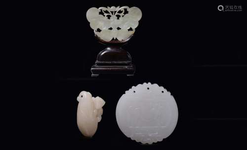 Three carved and fretworked white jades: a small fruit with  ...
