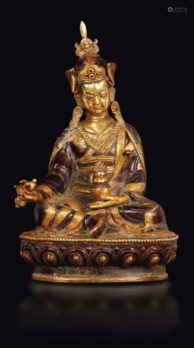 A burnished and gilt bronze figure of Padmasambhava with dorje  ...