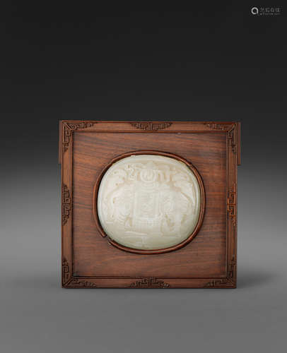 A carved nephrite plaque in a wood mount