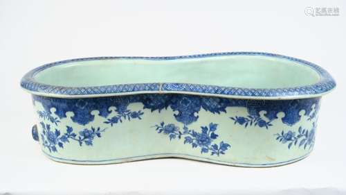 Bourdalou en porcelaine émaillée blanc bleu à décor de végétaux. <br/>Compagnie des Indes, XVIII ème siècle. <br/>57 x 33 cm