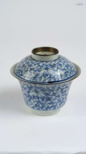 Bol couvert en porcelaine de Huê à décor blanc bleu de grandes fleurs sur un fond géométrisé de petites fleurs, monté métal, 2 marques à 4 caractères.<br/>Chine, dynastie Qing,  XVIII ème siècle. <br/>H. 9 cm<br/>Diam. 10 cm