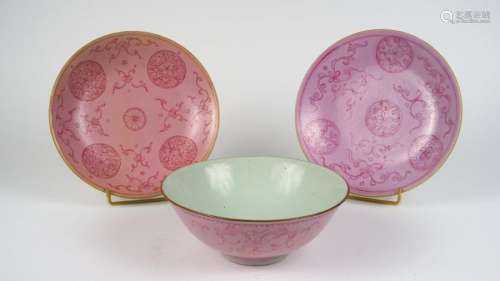 Trois pièces en porcelaine à décor stylisé rouge sur fond rose, porte une marque apocryphe. <br/>Chine, XIX ème siècle. <br/>Diam. 18,5 à 20 cm