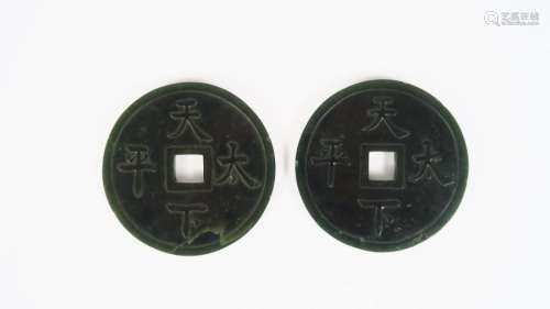 Deux disques bi en jade épinard, à décor de quatre idéogrammes sur chaque face, double écriture Chine et Mongole. <br/>Chine, début Xxème siècle. <br/>Diam. 7 cm