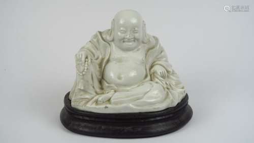 Sujet en porcelaine blanche figurant un bouddha souriant. <br/>Chine, XX ème siècle. <br/>H. 15 cm
