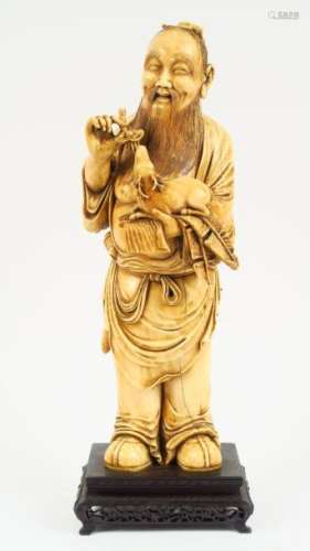Statue en ivoire, représentant un sage présentant une branche de lingzhi à un daim miniature. <br/>Chine, vers 1940.<br/>H. 31,5 cm<br/>Poids. 2226 grs<br/>Vente aux enchères conforme aux dernières instructions (17/11/2017) du Ministère transmises par le Conseil des Ventes.