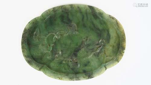 Plaque en jade vert épinard à bord polylobé, sculptée d'oiseaux évoluant sur une pièce d'eau parmi des lotus (petite égrenure). <br/>Chine, dynastie Quing, période Qianlong. XVIII ème siècle. <br/>H. 16 cm<br/>(Petite égrenure)