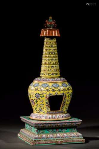 Stupa, sanctuaire bouddhique en porcelaine de la famille rose sur fond jaune reposant sur un piédestal quadrangulaire  surmonté  d'un kalasha l'un des huit emblèmes bouddhiques supporté par un parasol. Le décor s'harmonise en frises lotiformes rinceaux floraux et guirlandes d'animaux chimériques et perles. Chine. Dynastie Qing. 19 ème siècle.  Ht: 53 cm