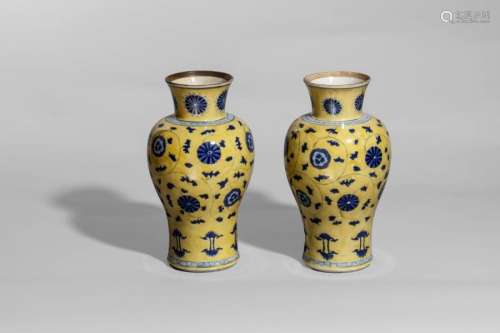 Paire de vases balustre en porcelaine décorée de rinceaux à fleurs épanouies en bleu sur fond jaune et de deux frises géométriques à l'épaulement et à la base. L'intérieur émaillé en blanc.  A la base le double cercle en bleu cobalt sous glaçure blanche. Chine. Dynastie Qing. Période de l'empereur Kangxi. 1662 à 1722. Ht 26cm x diam au col 9cm.